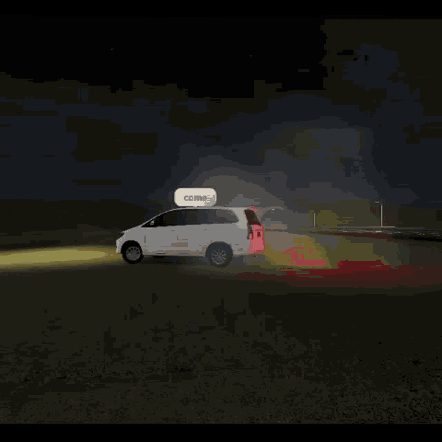 a white car is driving down a grassy field at night .