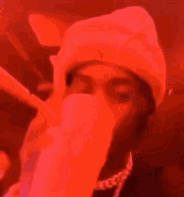 a man in a hat is holding a gun in his hand and smiling .