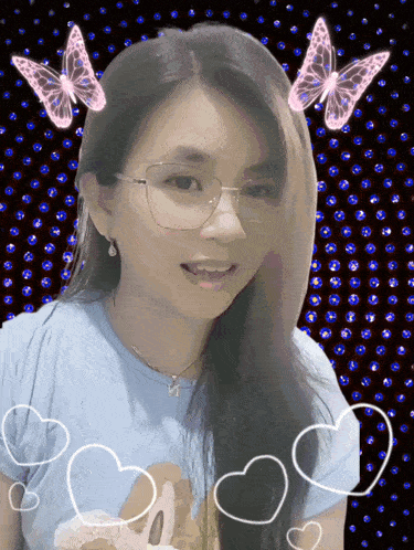 a woman wearing glasses and a teddy bear shirt is surrounded by butterflies and hearts
