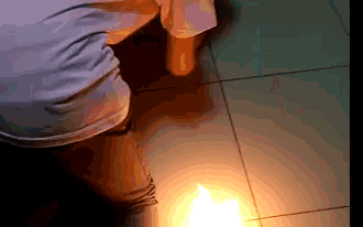 a person is kneeling down in front of a candle