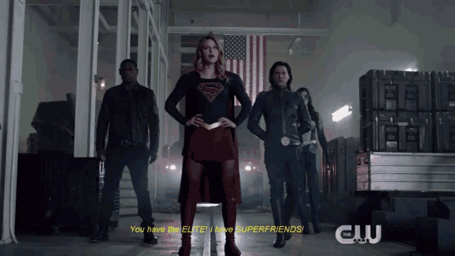 a woman in a superman costume stands in front of a group of people