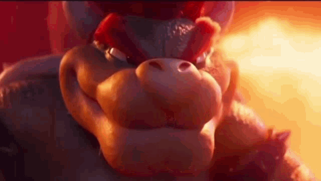 a close up of bowser 's face in a video game with a fire in the background .