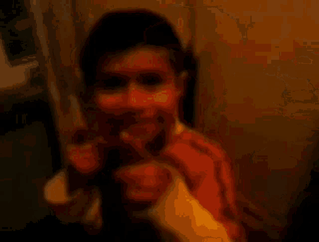 a blurry picture of a young boy sitting in a chair smiling .