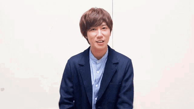 a man with his arms outstretched is wearing a blue jacket and striped shirt