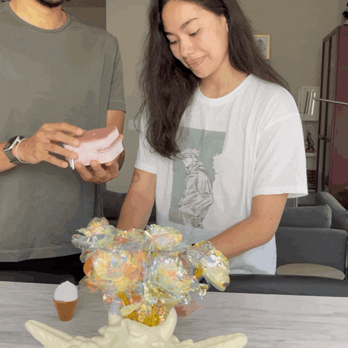 a man and a woman are looking at a flower arrangement