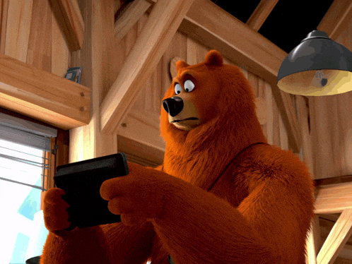 a cartoon bear is holding a black tablet