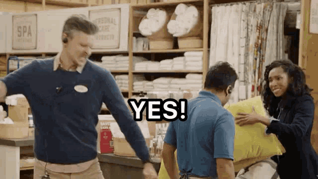 a man in a blue shirt is holding a yellow pillow while a woman says yes