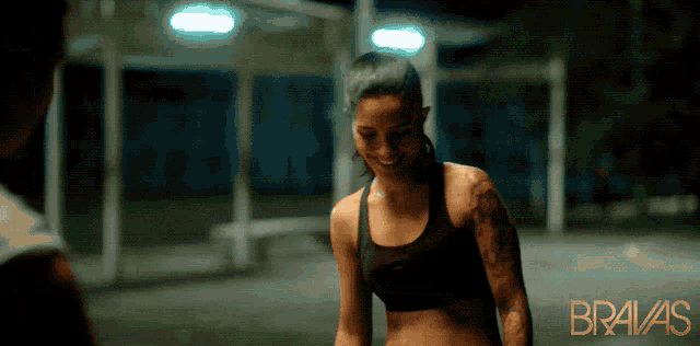 a woman with a tattoo on her arm is smiling in a bravas ad