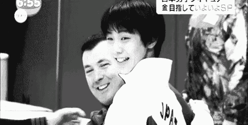 a black and white photo of a man holding a child on his back .