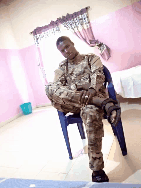 a man in a military uniform is sitting in a blue chair