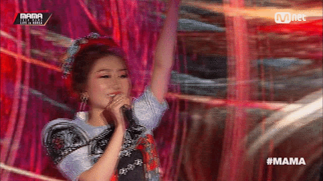 a woman singing into a microphone with the hashtag mama on the bottom