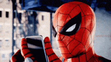 a close up of a person in a spiderman costume looking at a cell phone