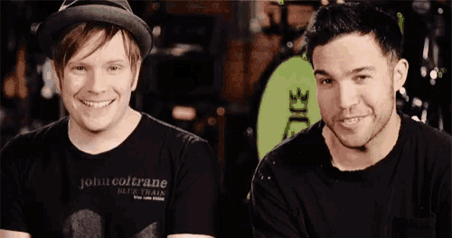 two men are standing next to each other and smiling for the camera .