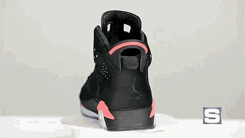 a pair of black and pink air jordan 6 sneakers on a white surface
