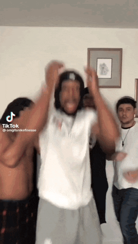 a group of men are dancing in a living room with a tiktok watermark
