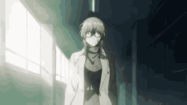 a woman with glasses and a white coat stands in a dark hallway
