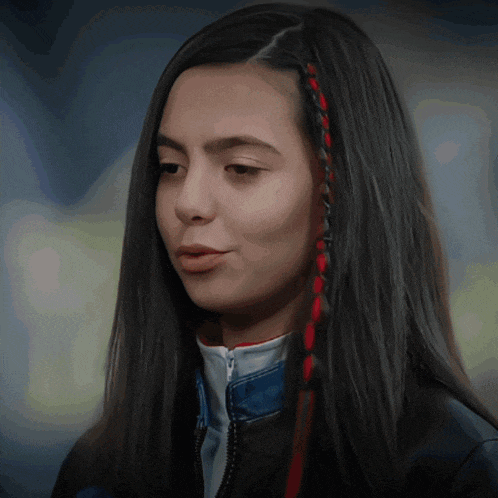 a woman with long black hair has red and black braids
