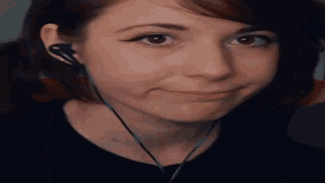 a close up of a woman wearing headphones and making a funny face