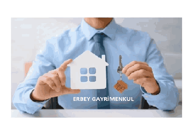 a man in a blue shirt and tie holds a model house and a key