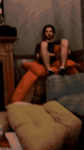 a man is sitting on a couch with his legs up