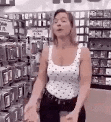 a woman is standing in a store with her hands outstretched .