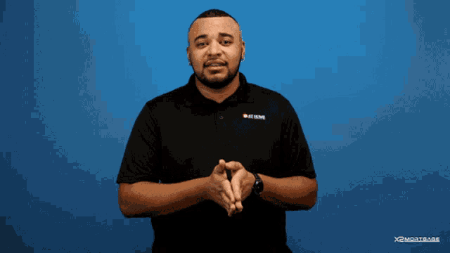 a man stands in front of a blue background that says " thank yo "
