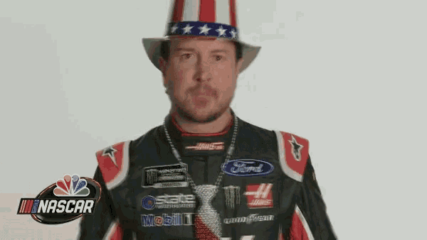 a man wearing an uncle sam hat and a necklace is standing in front of a nascar logo .