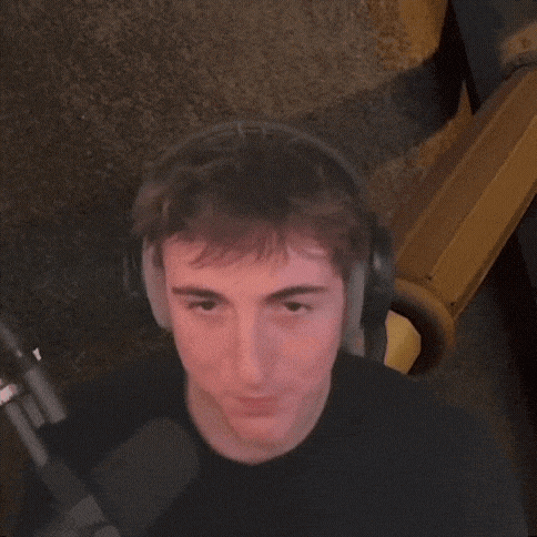 a young man wearing headphones is making a funny face .
