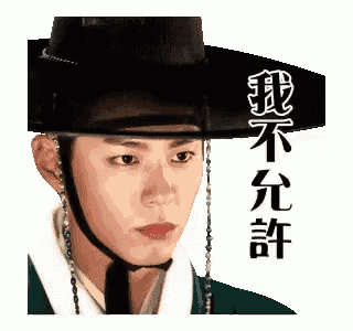 a man wearing a hat with chinese writing on it is looking at the camera .