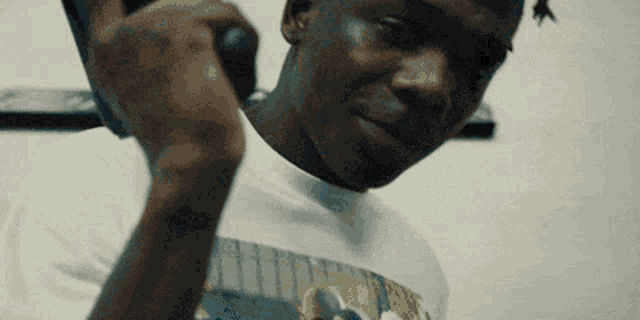 a close up of a man talking on a cell phone while wearing a white shirt .