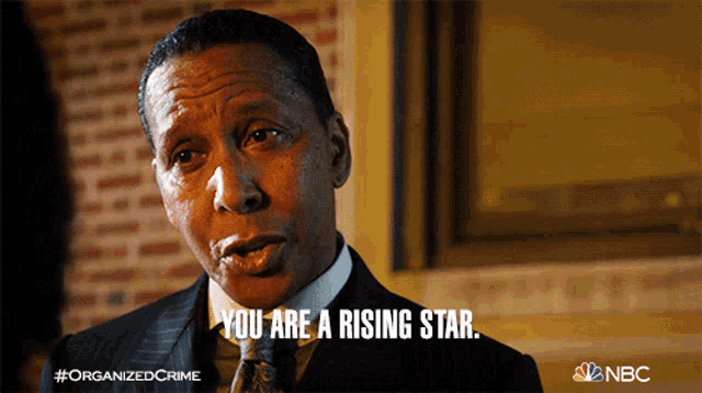 a man in a suit and tie is saying you are a rising star