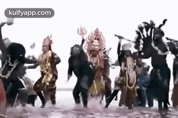 a group of people in costumes are dancing in a pool of water .