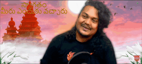 a man in a black shirt is smiling in front of a pink background with a foreign language written on it