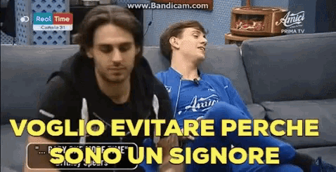 two men are sitting on a couch with the words voglio evitare perche sono un signore in the corner