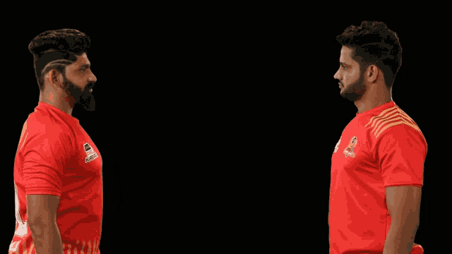 a man wearing a red shirt with the number 2 on the back shakes hands with another man