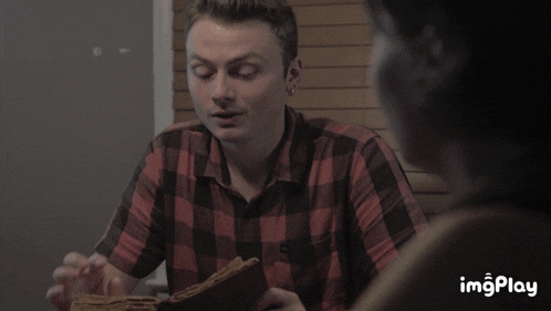 a man in a plaid shirt says " it 's a cult " while sitting at a table