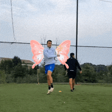 a man wearing a gray jacket and blue shorts has pink wings on his arms