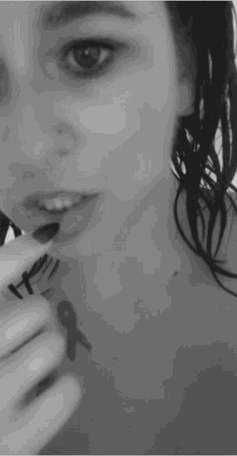 a black and white photo of a woman with a tattoo on her chest