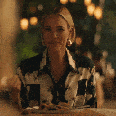 a woman is sitting at a table with a plate of food