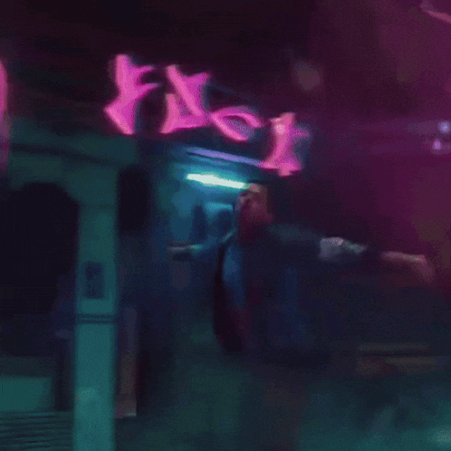a blurry picture of a person standing in front of a sign that says ' r ' on it