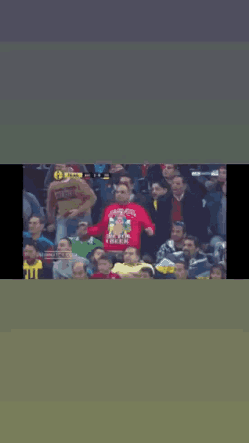a man wearing a sweater that says supreme stands in the crowd