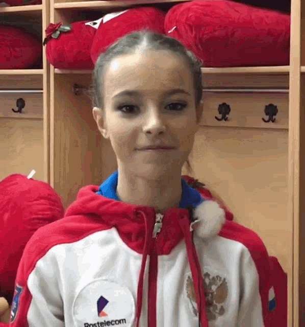 a young girl wearing a red and white jacket that says protelecom