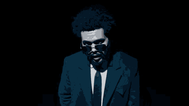 a man in a suit and tie with sunglasses on