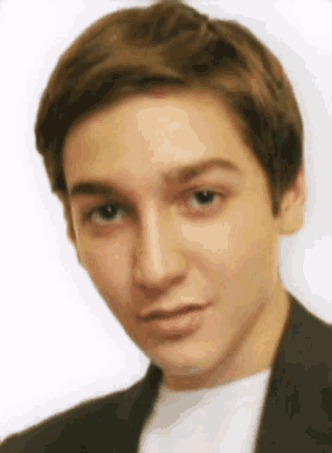 a close up of a young man 's face with a white background