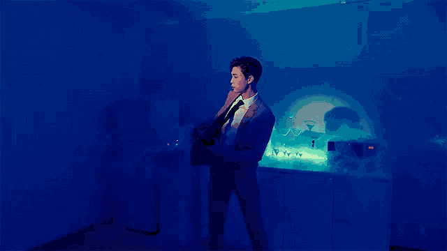 a man in a suit and tie is holding a bottle of wine