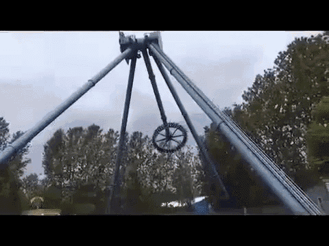 a roller coaster at an amusement park with trees in the background