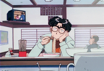 a man eating noodles in a restaurant with a tv on the wall