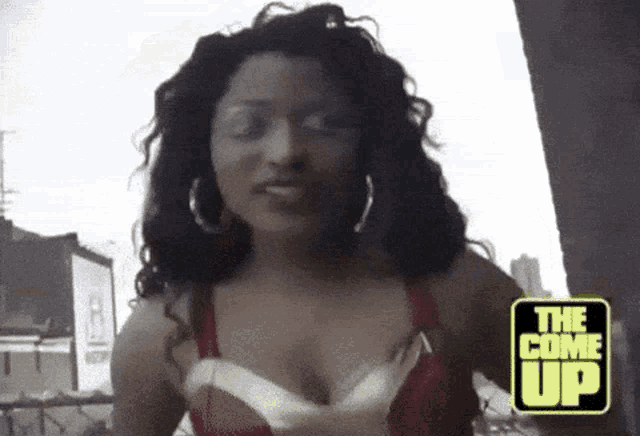 a woman in a red bra is standing next to a sign that says the come up