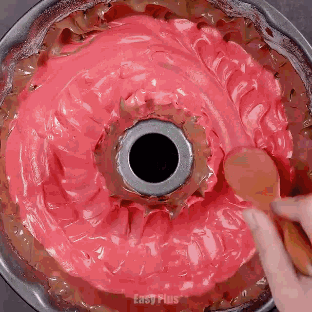 a bundt cake with red frosting and easy plus written on the bottom right