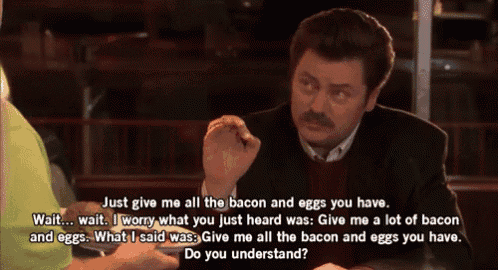 a man with a mustache is sitting at a table and talking to another man